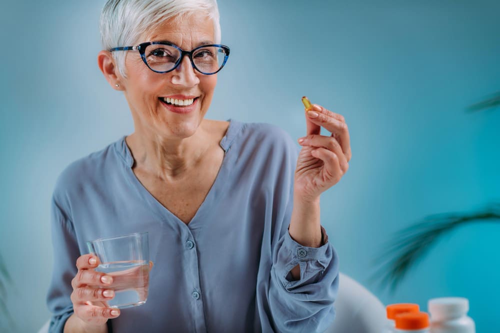 mulher idosa tomando suplemento na menopausa