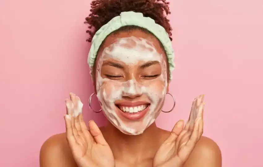 mulher passando sabonete facial no rosto e evitando os erros comuns de skincare